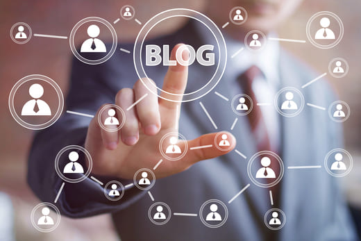 Darstellung der großen Reichweite SEO-optimierter Blogartikel: Mann drückt virtuellen Knopf mit Aufschrift Blog.