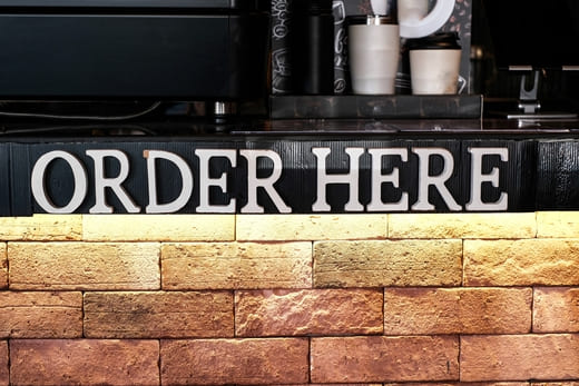 Schriftzug „Order Here“: Textagentur, Texter, Content-Manager für Ihre Branche gesucht? Sie können hier Texte bestellen.