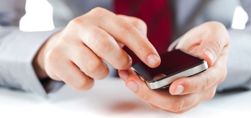 Geschäftsmann liest in den FAQ (Häufigen Fragen) der Textagentur / des Texters Antworten auf Fragestellungen.